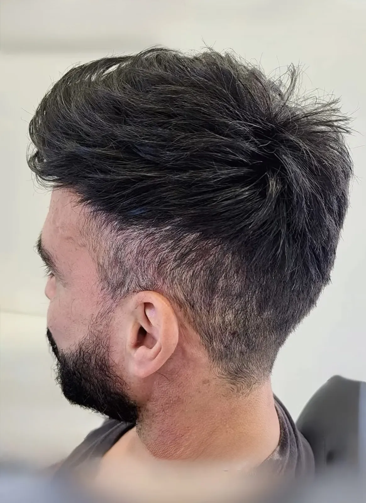 Real HEADS client — full dark hair with taper fade after his hair system, profile view